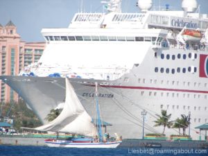 Bahamian sloop against a giant cruise ship in Nassau